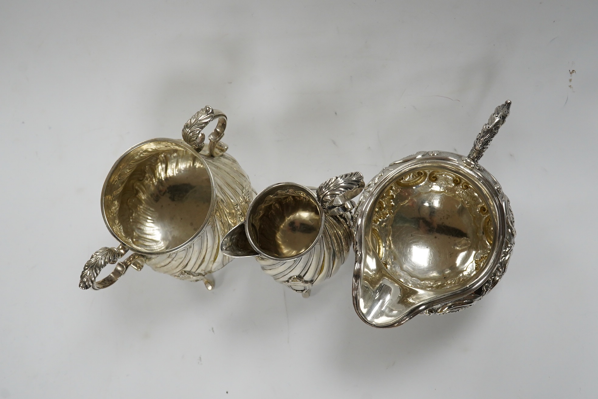 A late Victorian silver cream jug and sugar bowl, by Mappin & Webb, London, 1900 and an earlier William IV silver cream jug, London, 1835, 16.1oz. Condition - fair to good